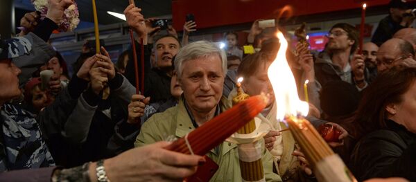 Crentes durante a cerimônia do Fogo Sagrado em Moscou Crentes durante a cerimônia do Fogo Sagrado em Moscou - Sputnik Brasil