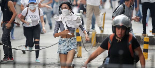 Manifestantes fogem da polícia durante os protestos contra o presidente venezuelano Nicolás Maduro em Caracas - Sputnik Brasil