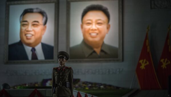 Um militar norte-coreano faz guarda de honor na frente de retratos de Kim Il-sung e Kim Jong-il durante os festejos em comemoração do 105 aniversário do nascimento do fundador do Estado da Coreia do Norte em Pyongyang - Sputnik Brasil
