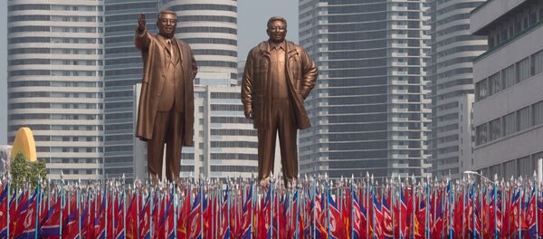 Participantes dos festejos comemorando os 105 anos de nascimento de Kim Jong-il são vistos com bandeiras na praça principal em Pyongyang Participantes dos festejos comemorando os 105 anos de nascimento de Kim Jong-il são vistos com bandeiras na praça principal em Pyongyang - Sputnik Brasil