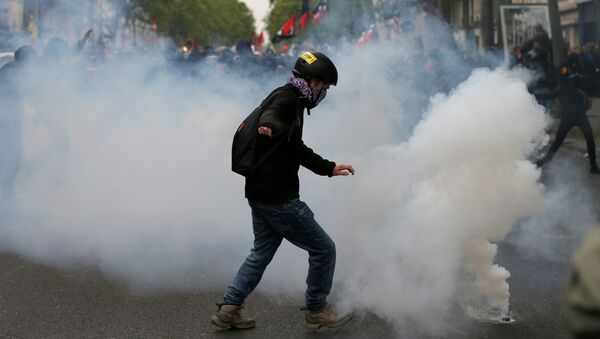 A protester kicks back a tear gas grenade during a demonstration for a social first round on the eve of the first round in the French presidential election, in Paris, France - Sputnik Brasil