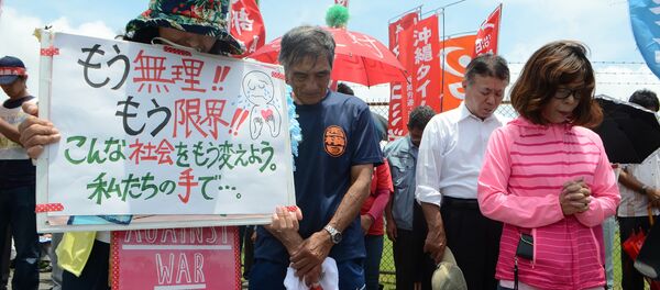 People offer a silent prayer in front of the US Kadena Air Base in Cyatan, Okinawa prefecture, to protest against the US military presence in Okinawa on May 21, 2016 - Sputnik Brasil