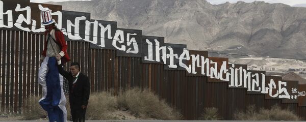 Protestors dressed as a diabolical Uncle Sam, on stilts, and Mexico's President Enrique Pena Nieto hold hands as they walk along the border fence in Ciudad Juarez, Mexico Sunday, Feb. 26, 2017. - Sputnik Brasil