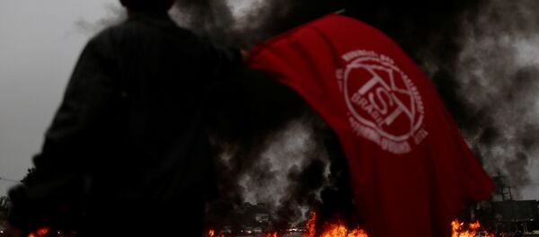 Um membro do MTST mostra a bandeira do movimento durante ato da greve geral de 28 de abril de 2017 em Brasília - Sputnik Brasil