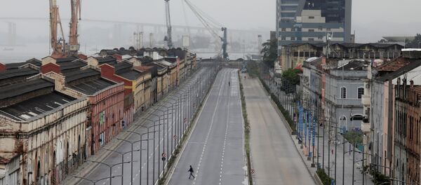 Uma pessoa cruza uma via pública vazia na área portuária do Rio de Janeiro no dia da greve geral, 28 de abril de 2017 - Sputnik Brasil