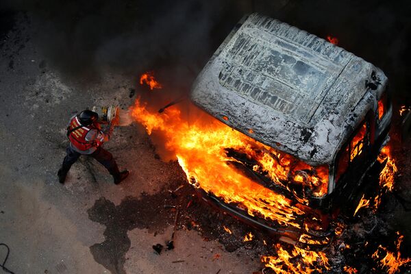Extinção de fogo durante os protestos contra o presidente da Venezuela, Nicolas Maduro, em Caracas - Sputnik Brasil