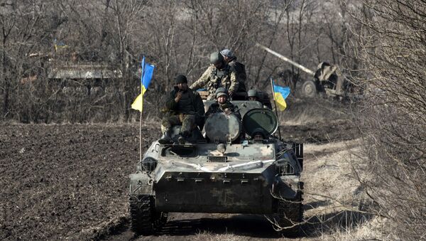 Ukrainian servicemen ride atop armored vehicle with a canon in tow and Ukrainian flags, near the village of Fedorivka, eastern Ukraine, Friday, Feb. 27, 2015 - Sputnik Brasil