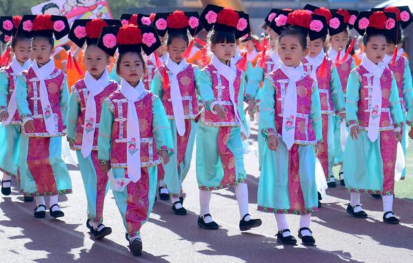 Pequenos estudantes desfilam com roupas tradicionais chinesas durante evento esportivo em Shenyang - Sputnik Brasil