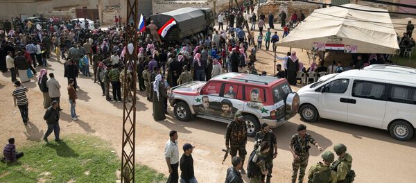 People gather around a Russian military truck to receive a food aid in Maarzaf, about 15 kilometers west of Hama, Syria, Wednesday, March 2, 2016 - Sputnik Brasil