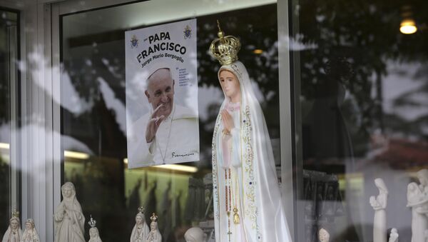 Nesta foto de 4 de maio de 2017, uma imagem mostrando Papa Francisco é vista na vitrine de uma loja que vende estátuas da Nossa Senhora de Fátima na cidade portuguesa de Fátima - Sputnik Brasil