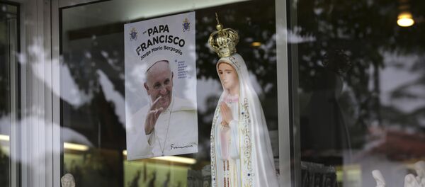 Nesta foto de 4 de maio de 2017, uma imagem mostrando Papa Francisco é vista na vitrine de uma loja que vende estátuas da Nossa Senhora de Fátima na cidade portuguesa de Fátima Nesta foto de 4 de maio de 2017, uma imagem mostrando Papa Francisco é vista na vitrine de uma loja que vende estátuas da Nossa Senhora de Fátima na cidade portuguesa de Fátima - Sputnik Brasil