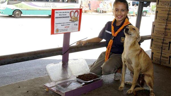 Giovanna Gabriely Santana de Lima com um dos cães abandonados alimentados por ela em Jaboatão dos Guararapes (PE) - Sputnik Brasil