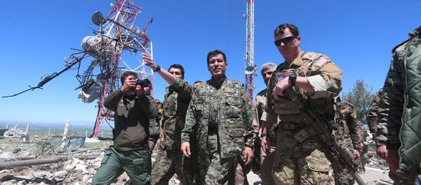 US military commander (R) walks with a commander (C) from the Kurdish People's Protection Units (YPG) as they inspect the damage at YPG headquarters after it was hit by Turkish airstrikes in Mount Karachok near Malikiya, Syria April 25, 2017. - Sputnik Brasil