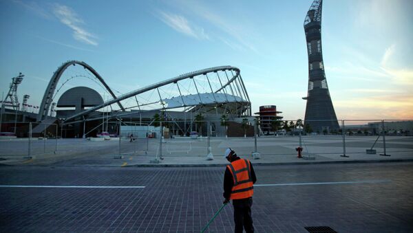 In this Jan. 3, 2011 file photo, a worker cleans the road outside Khalifa sport complex in Doha, Qatar - Sputnik Brasil