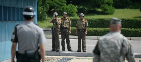 Soldados norte-coreanos tiram fotos de soldado sul-coreano e  de militar norte-americano junto à linha de demarcação que separa as duas Coreias (foto de arquivo) - Sputnik Brasil