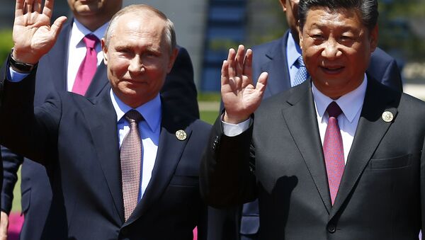 Presidentes Vladimir Putin e Xi Jingping acenam durante evento em Pequim - Sputnik Brasil