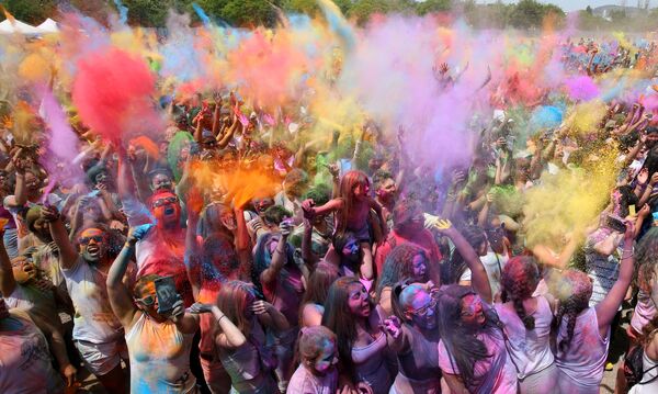 Pessoas jogam pó colorido durante o tradicional Festival de Holi em Santa Coloma de Gramenet, perto de Barcelona - Sputnik Brasil