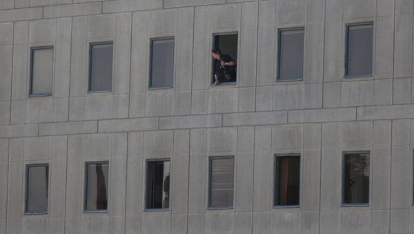 Policial iraniano olhando da janela do edifício do Parlamento iraniano - Sputnik Brasil