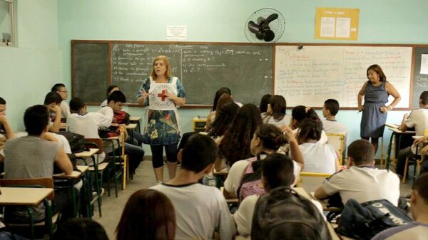 Uma profissional da Cruz Vermelha Internacional dando treinamento de segurança em escola da Maré, em 2013 Uma profissional da Cruz Vermelha Internacional dando treinamento de segurança em escola da Maré, em 2013 - Sputnik Brasil