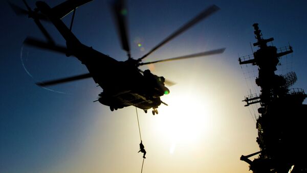 A US Marine fast ropes from a CH-53 Super Stallion helicopter during familiarization training on the flight deck of the amphibious assault ship USS Kearsarge June 30, 2013 - Sputnik Brasil