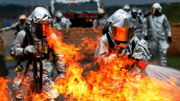 Unos bomberos intentan apagar el fuego (imagen referencial) - Sputnik Brasil