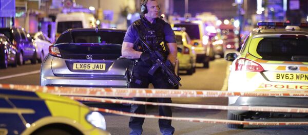An armed police officer mans a cordon on the Seven Sisters Road at Finsbury Park where a vehicle struck pedestrians in London Monday, June 19, 2017. Police say a vehicle struck pedestrians on a road in north London, leaving several casualties and one person has been arrested. - Sputnik Brasil
