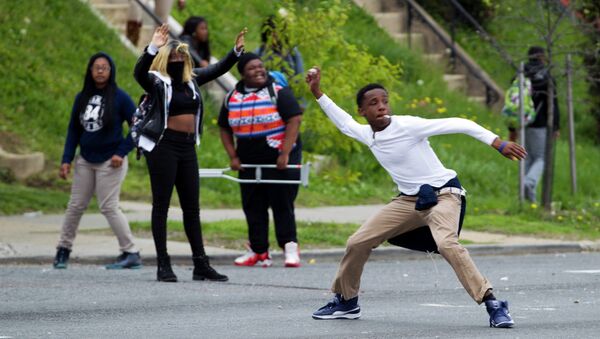 Demonstrators throw rocks at the police after the funeral of Freddie Gray on Monday, April 27, 2015, at New Shiloh Baptist Church in Baltimore. - Sputnik Brasil