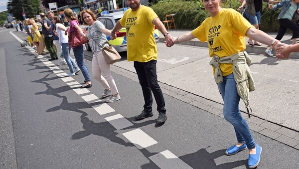 Participants of the anti-nuclear Chain Reaction demonstration build a human chain to protest against the operation of Belgium's Tihange 2 and the Netherland's Doel 3 nuclear power plants on June 25, 2017 in Aachen, western Germany, close to the border with Belgium and the Netherlands - Sputnik Brasil