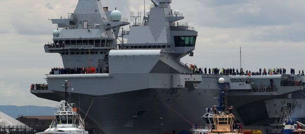The British aircraft carrier HMS Queen Elizabeth is pulled from its berth by tugs before its maiden voyage, in Rosyth, Scotland, Britain June 26, 2017. - Sputnik Brasil