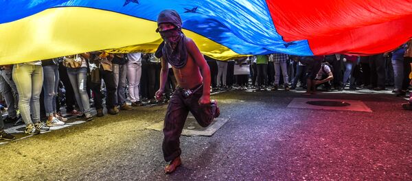 Menino corre sob a bandeira venezuelana durante protestos de jornalistas e funcionários da mídia em Caracas - Sputnik Brasil