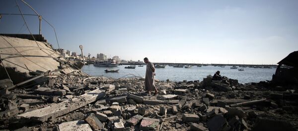 A Palestinian man inspects the damage of a police post, following an Israeli missile strike killing four boys from the same extended Bakr family, in Gaza City, Wednesday, July 16, 2014. - Sputnik Brasil