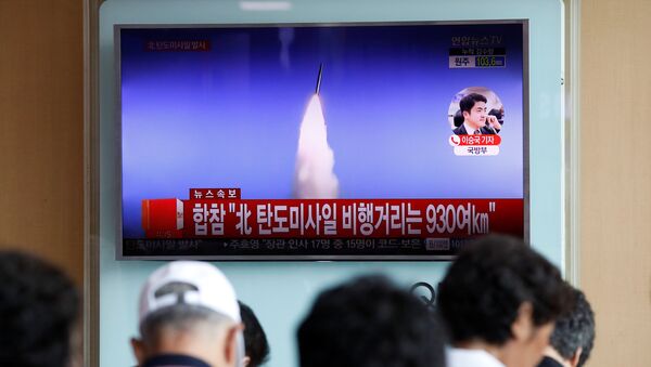 Pessoas em Seul vendo a notícia na TV sobre o teste de míssil balístico na Coreia do Norte - Sputnik Brasil