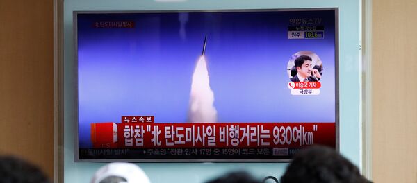 Pessoas em Seul vendo a notícia na TV sobre o teste de míssil balístico na Coreia do Norte, em 4 de julho de 2017 - Sputnik Brasil
