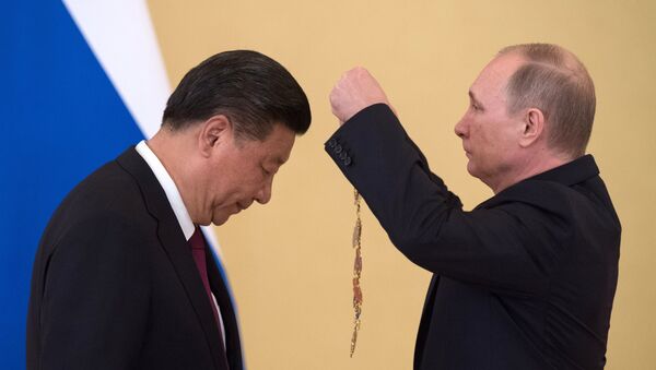 Xi Jinping se inclina para receber a ordem de Santo André Apóstolo Protocletos das mãos de Vladimir Putin, em 4 de julho de 2017 - Sputnik Brasil