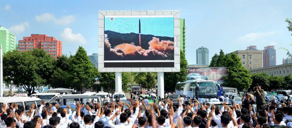 Norte-coreanos observando o teste do míssil balístico Hwasong-14 - Sputnik Brasil