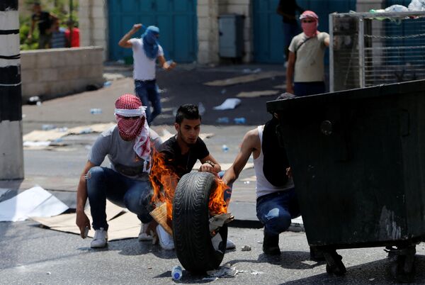 Manifestantes palestinos queimam um pneu em Belém em 21 de julho de 2017; confrontos com polícia começaram após tensão por causa da entrada dificultada ao Monte do Templo - Sputnik Brasil