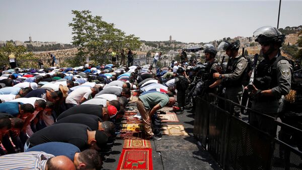Palestinos religiosos rezam na rua em Jerusalém, vigiados pela polícia de Israel, em 21 de julho de 2017 - Sputnik Brasil