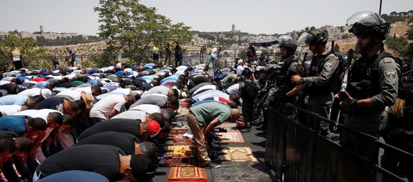 Palestinos religiosos rezam na rua em Jerusalém, vigiados pela polícia de Israel, em 21 de julho de 2017 - Sputnik Brasil