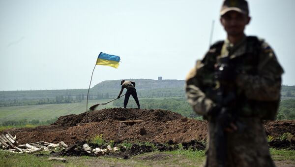Militar ucraniano mantem sua posição, enquanto trabalhadores estão cavando trincheiras na linha da frente do confronto contra milicianos independentistas no Leste da Ucrânia em 26 de maio de 2015 - Sputnik Brasil