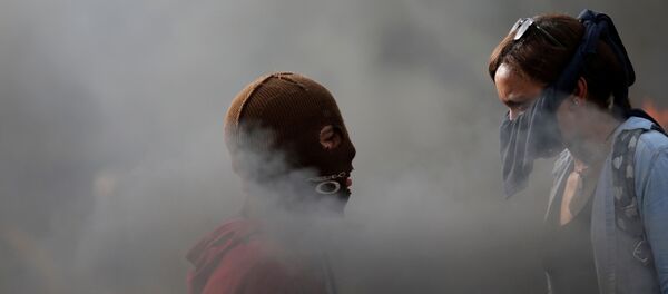 Manifestantes se olham enquanto se reúnem contra o governo do presidente da Venezuela, Nicolas Maduro, em Caracas - Sputnik Brasil