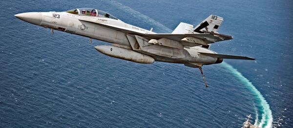 Um caça-bombardeiro americano F/A-18F Super Hornet sobrevoa o porta-aviões da Marinha dos EUA USS Gerald R. Ford, enquanto este testa seus novos sistemas EMALS e AAG no Atlântico - Sputnik Brasil