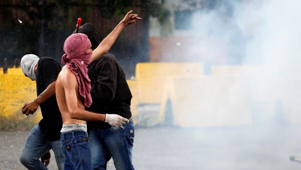 Um manifestante gesticula durante confrontos com forças de segurança perto da base militar de Fuerte Paramacay em Valência, Venezuela 6 de agosto de 2017. - Sputnik Brasil