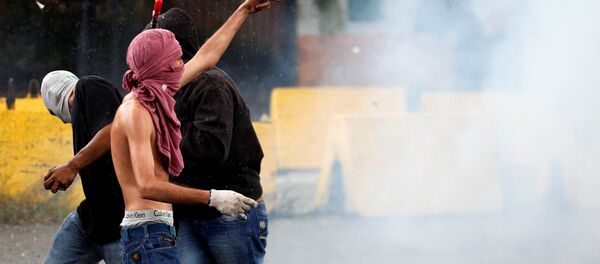 Um manifestante gesticula durante confrontos com forças de segurança perto da base militar de Fuerte Paramacay em Valência, Venezuela 6 de agosto de 2017. - Sputnik Brasil