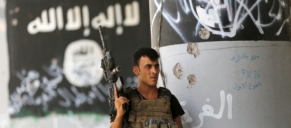 Soldado iraquiano em frente à pichação do Daesh - Sputnik Brasil