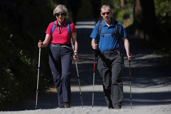 A primeira-ministra do Reino Unido, Theresa May, com seu marido durante as férias nos Alpes - Sputnik Brasil