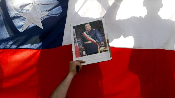 Supporters of former dictator Gen. Augusto Pinochet hold a Chilean flag and a portrait of Pinochet outside the Military Hospital in Santiago, Chile, Monday, Dec. 4, 2006 - Sputnik Brasil