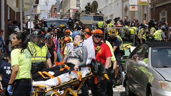 Rescue personnel help injured people after a car ran into a large group of protesters after a white nationalist rally in Charlottesville, Va., Saturday, Aug. 12, 2017. - Sputnik Brasil