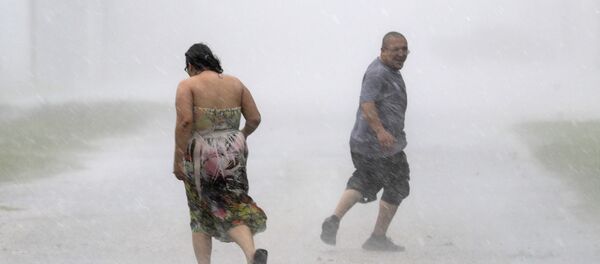 Texans run through the street during a band of heavy rain from Hurricane Harvey Saturday, Aug. 26, 2017, in Palacios, Texas. - Sputnik Brasil