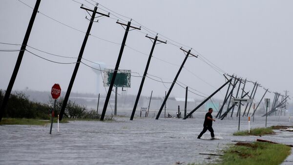 A man walks through floods waters and onto the main road after surveying his property which was hit by Hurricane Harvey in Rockport, Texas, U.S. August 26, 2017. - Sputnik Brasil