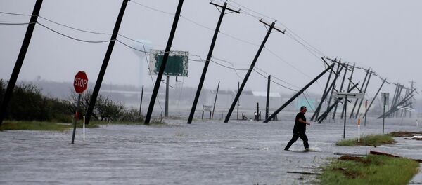 A man walks through floods waters and onto the main road after surveying his property which was hit by Hurricane Harvey in Rockport, Texas, U.S. August 26, 2017. - Sputnik Brasil